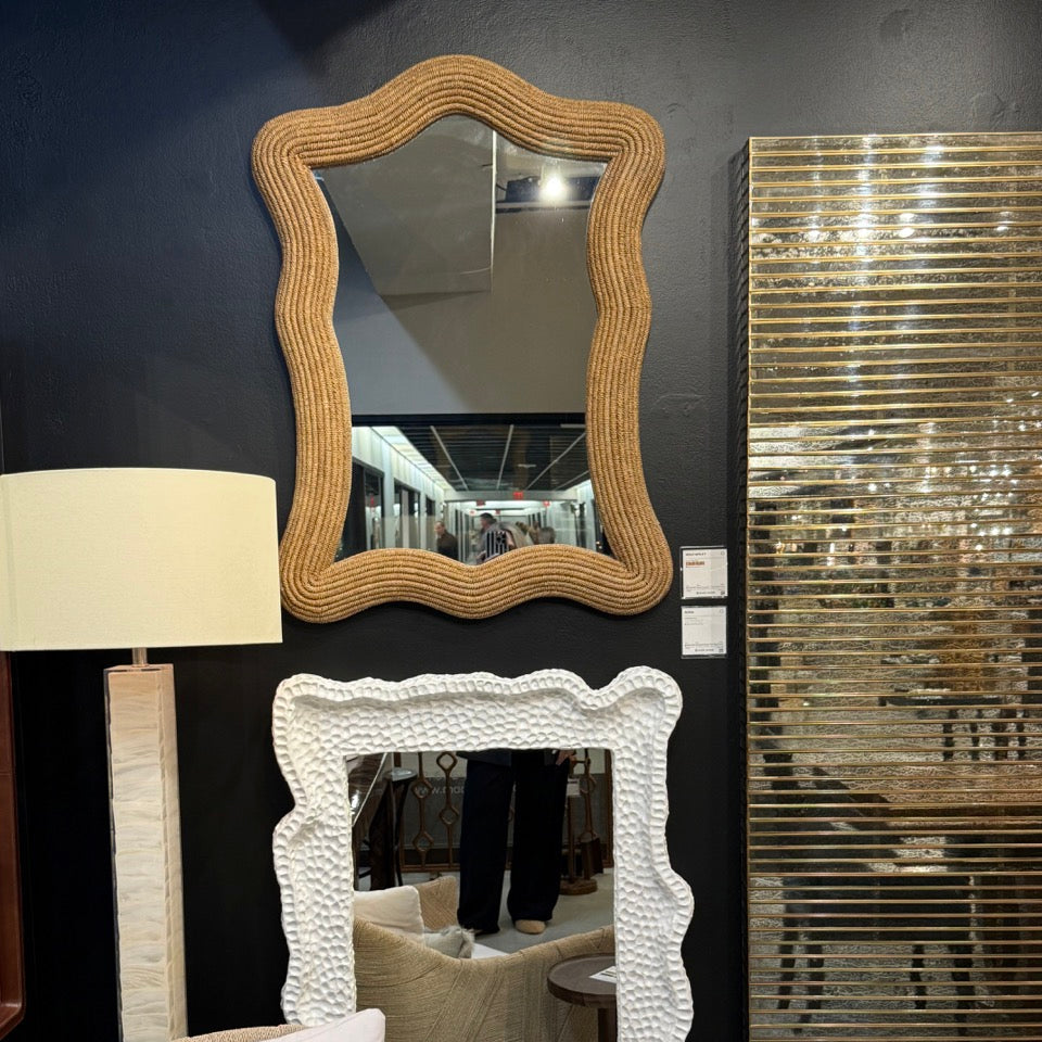 Decorative mirrors with unique frames on a dark wall.