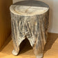 Wooden stool made from a tree stump on a wooden floor.