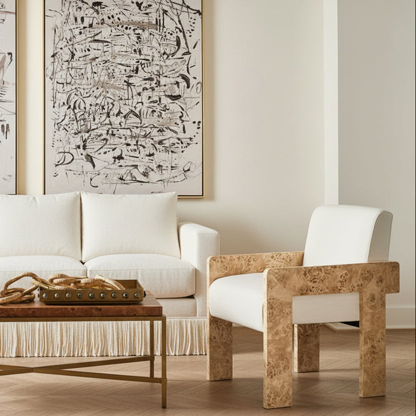 Modern living room with white sofa, marble armchair, and abstract art on the wall.