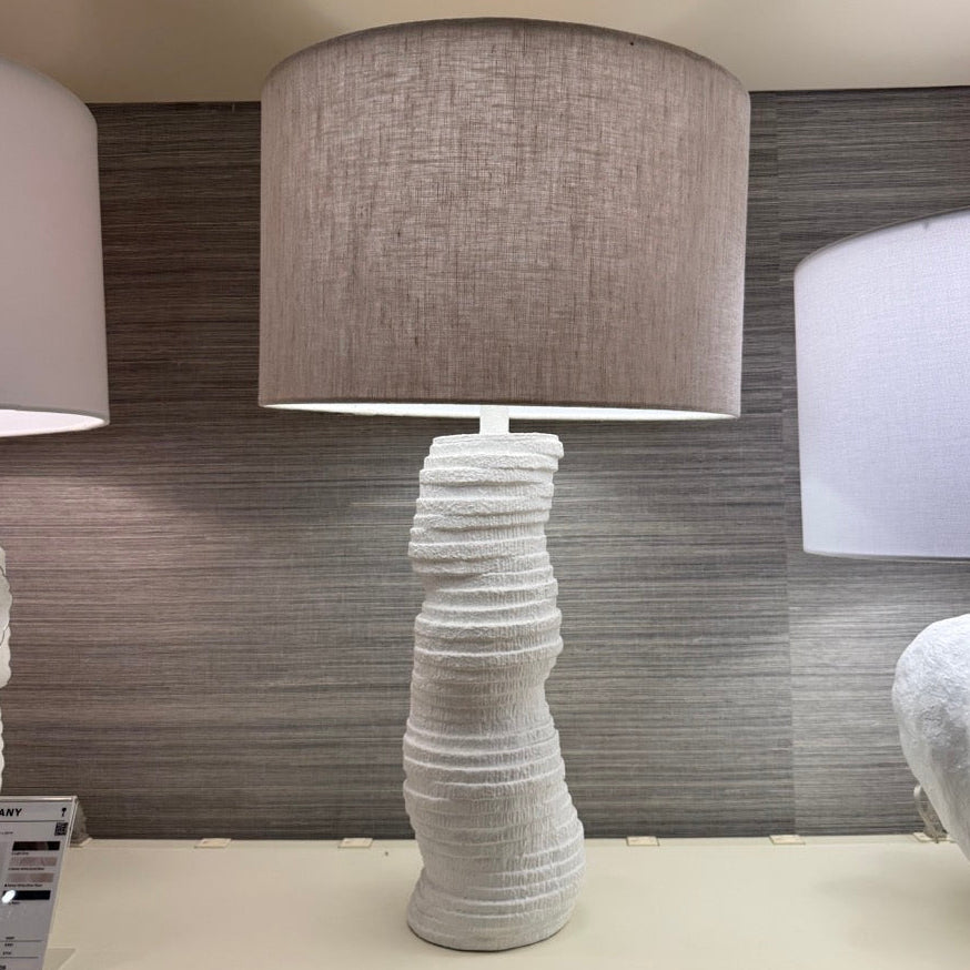 Textured floor lamp with a gray shade in a showroom setting