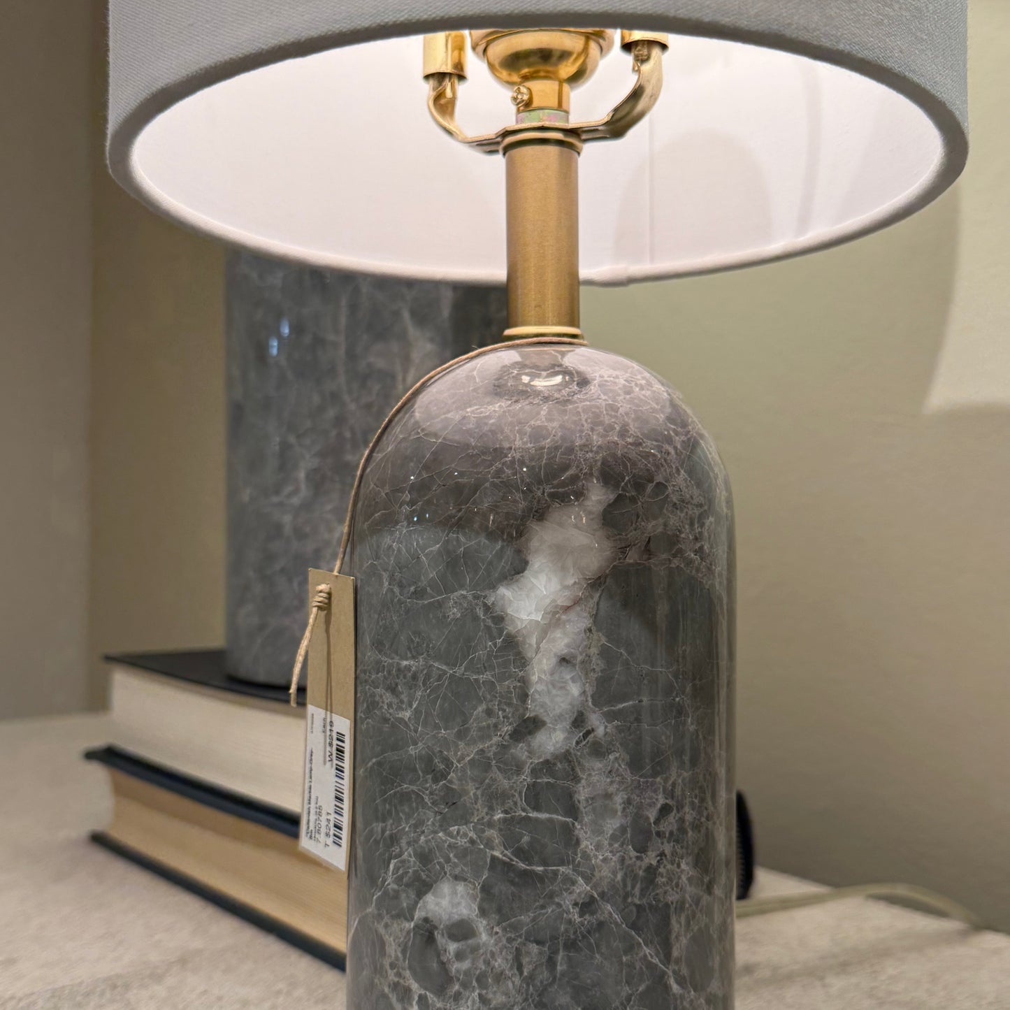 Marble-textured table lamp with a gray shade on a neutral background