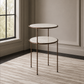 A two-tier nesting side table with round white marble-look tops and distressed bronze metal legs, shown in a styled interior room with a window, paneled wall, and striped rug.