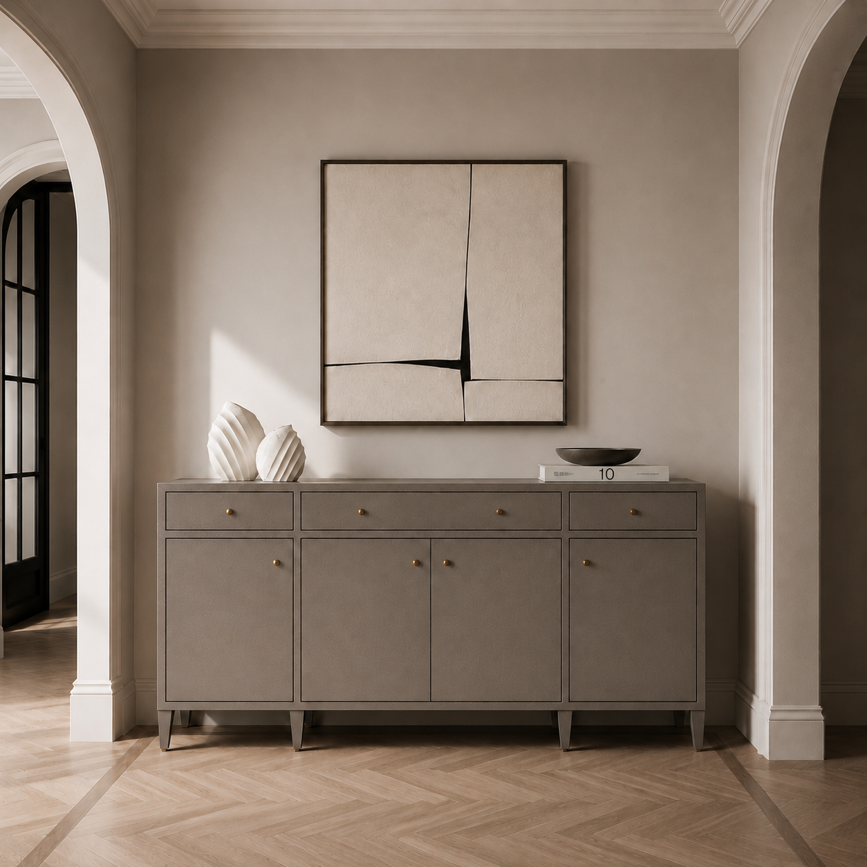 A modern gray sideboard cabinet with brass knobs, styled in a minimalist entryway with a matching abstract wall art piece above it.