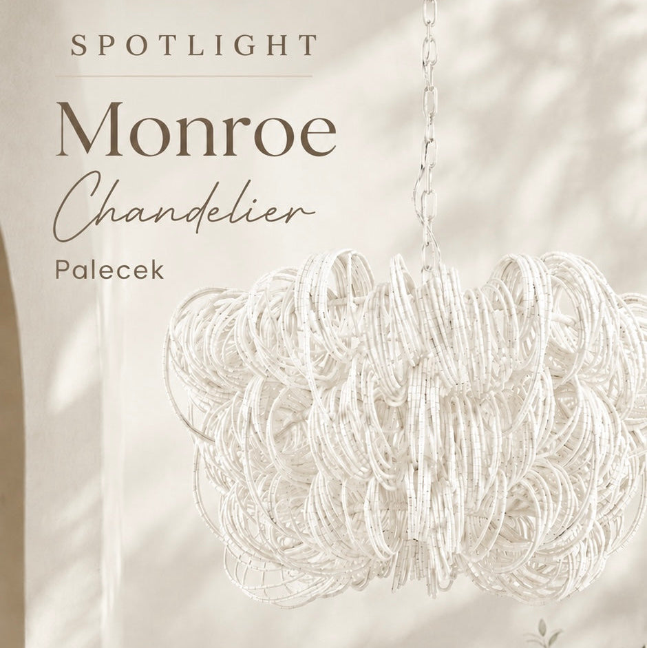 White chandelier labeled 'Monroe' by Palecek against a neutral wall with decorative elements.