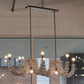 Modern chandelier hanging in a room with glass walls and brick wall background