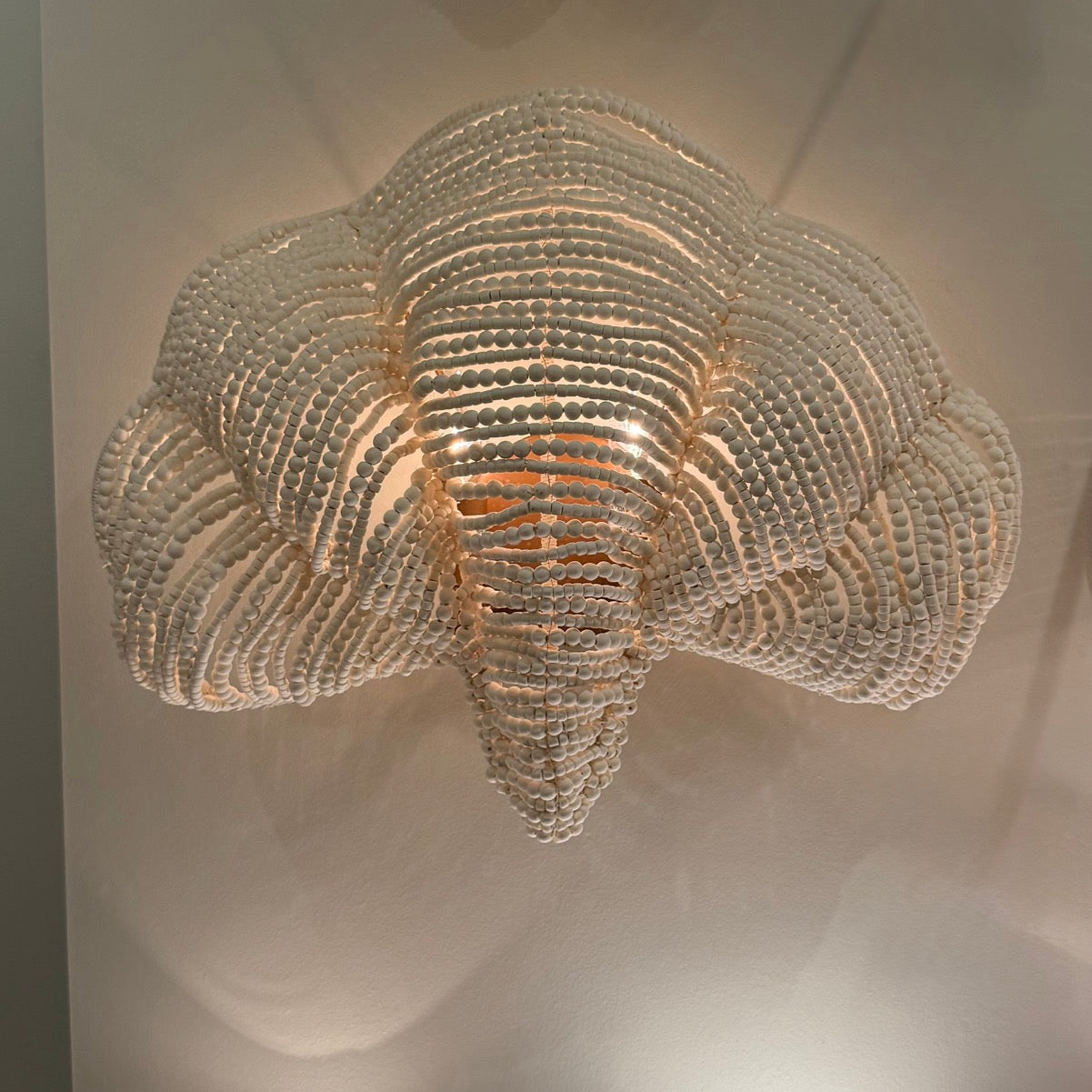 Decorative wall light fixture with a cloud-like design on a neutral background