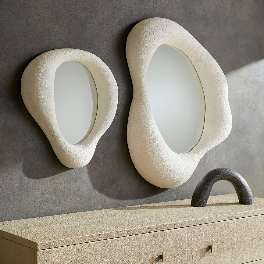 Two modern wall mirrors with a textured, organic design on a gray wall.