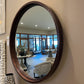 Round mirror with a leather frame in a showroom
