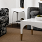 Modern living room with a white coffee table, patterned armchair, and plaid sofa.