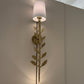 Decorative wall lamp with leaf design on a neutral wall.
