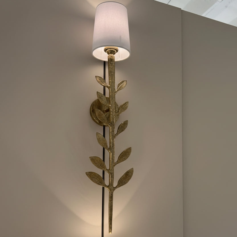 Decorative wall lamp with leaf design on a neutral wall.