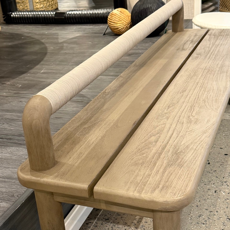 Wooden bench with a woven backrest on a patio