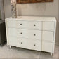 White dresser with gray lamp in a room setting