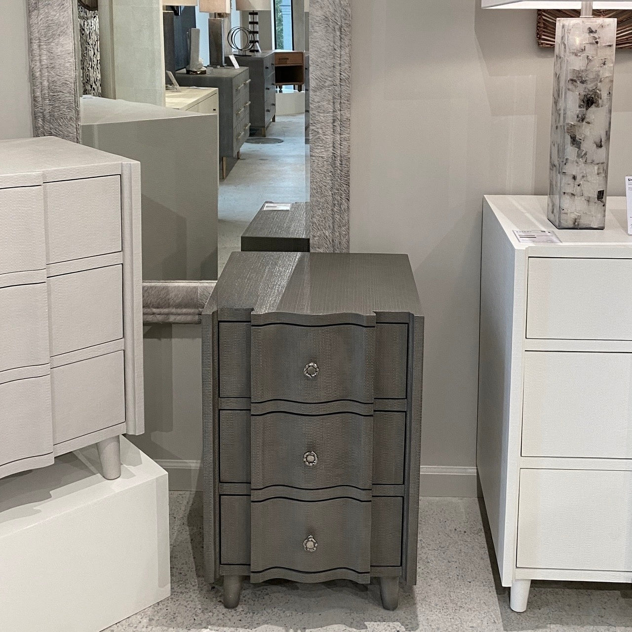 Gray dresser with silver knobs in a showroom setting