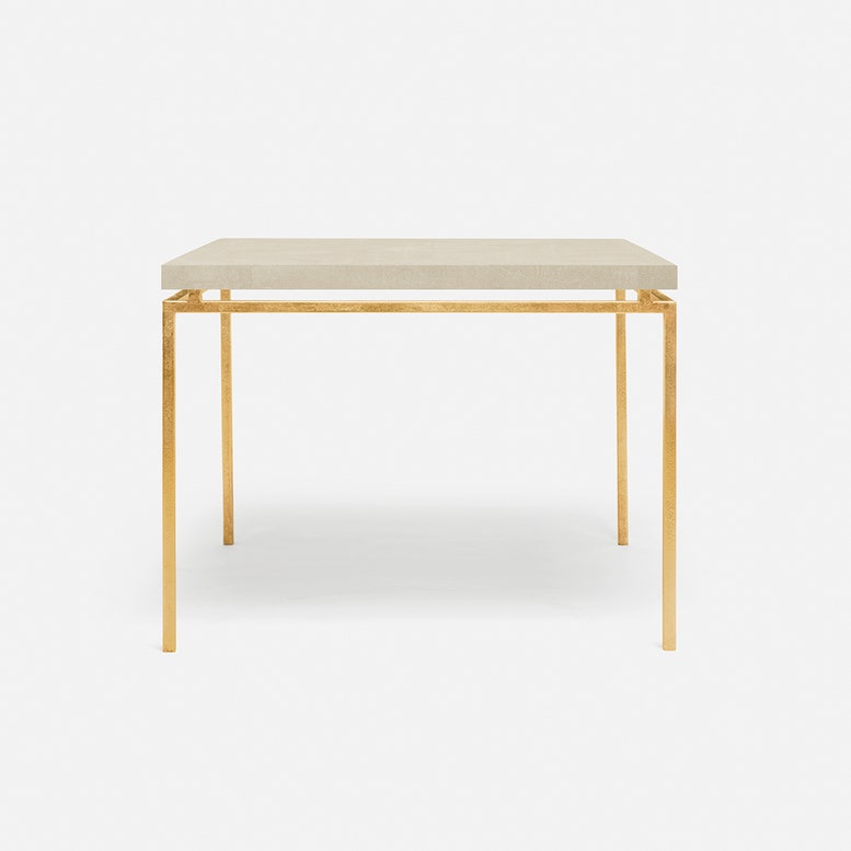 A modern rectangular game table with a ivory textured faux shagreen top and slim gold metal legs, shown against a plain white background.
