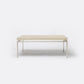 A rectangular coffee table with a light beige textured top and a slim silver metal frame, shown against a plain white background.