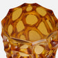 Octagonal amber-colored glass vase on a white background