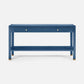 A blue console table with two drawers, two small gold knobs, and an open lower shelf, shown against a light gray studio background.