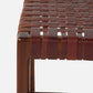 Close-up of a woven leather stool seat in a warm reddish-brown color, attached to a dark wood frame, shown against a plain light gray background.