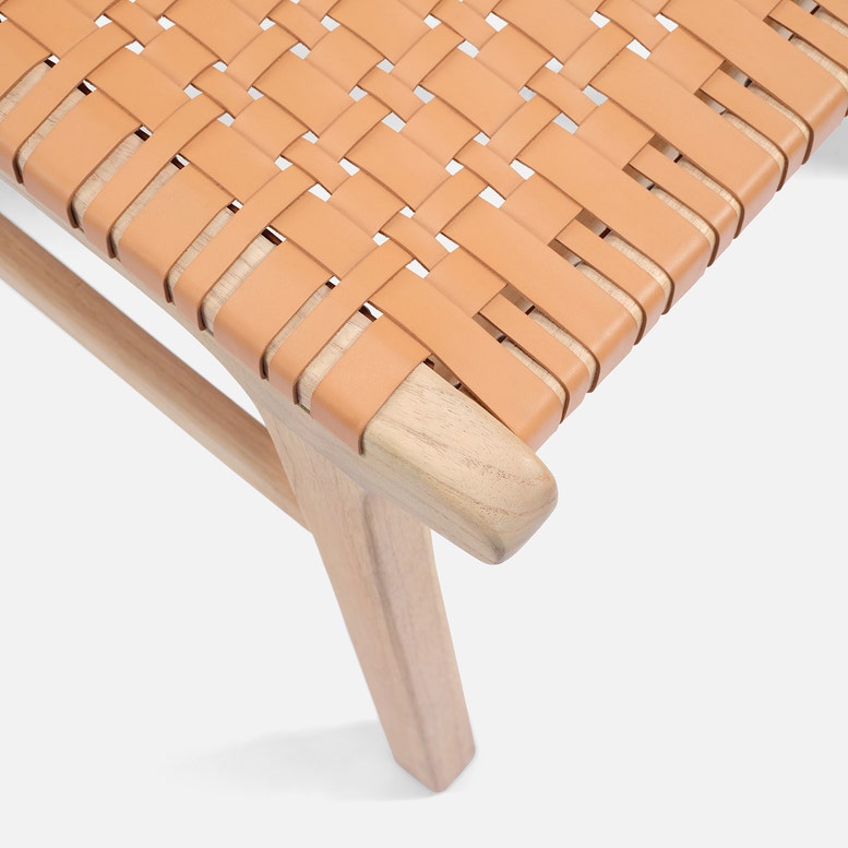 Close-up of a woven chair seat with wooden legs on a white background