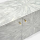 A modern sideboard cabinet featuring a light gray and white geometric mosaic inlay pattern on the doors and top, accented with two gold cabinet handles.
