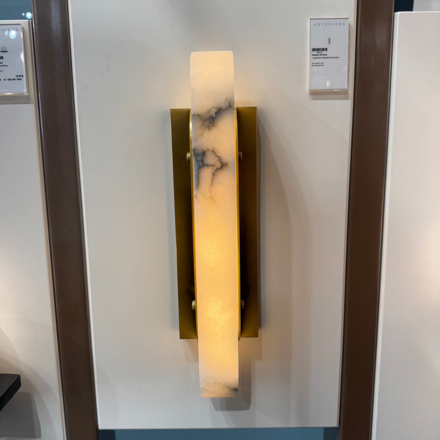 Wall-mounted light fixture with marble-like design on a glass panel