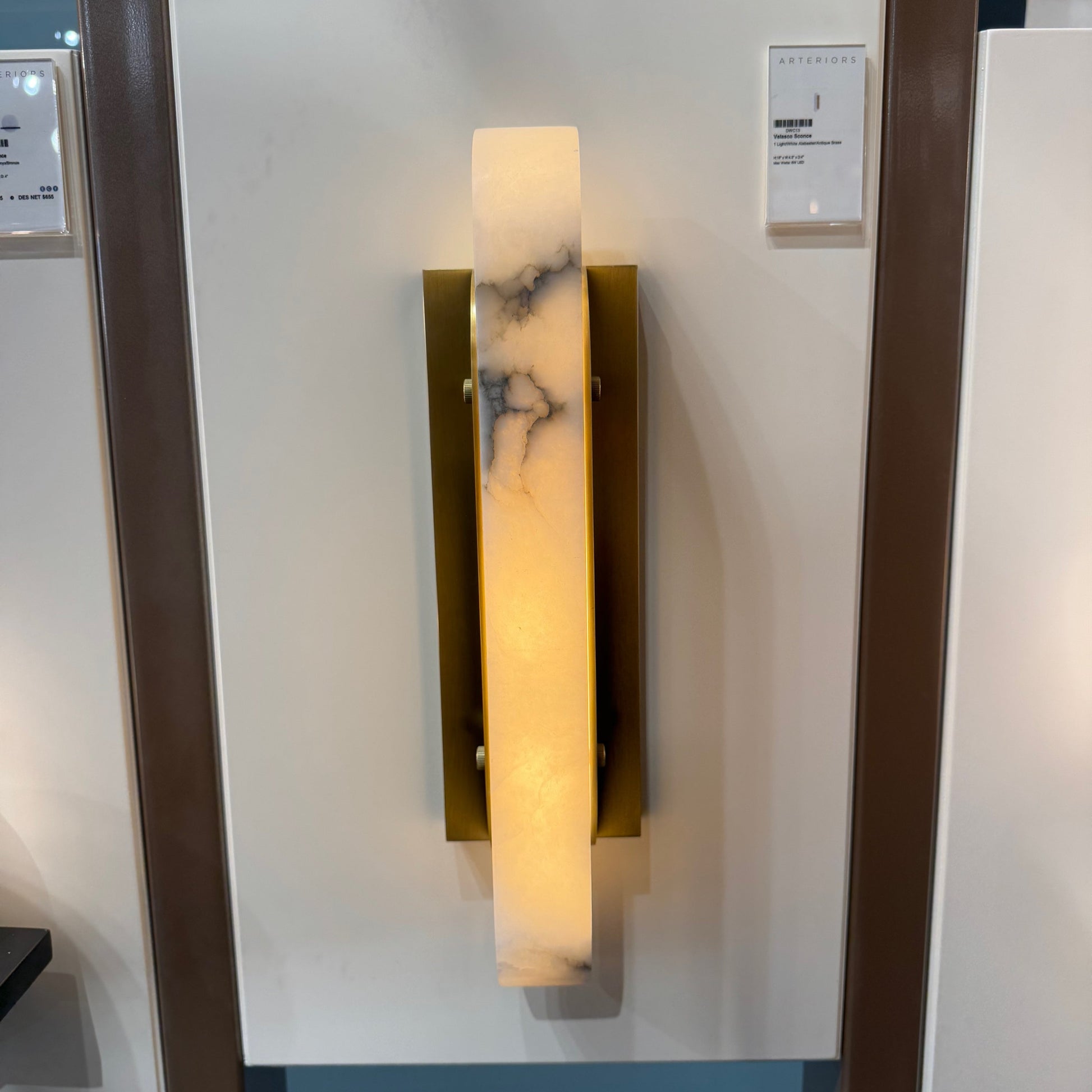 Wall-mounted light fixture with marble-like design on a glass panel