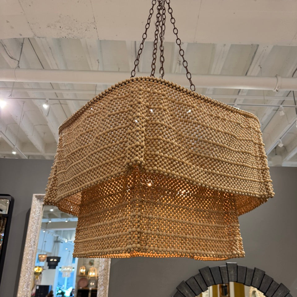 Woven pendant light hanging in a room with mirrors on the wall.