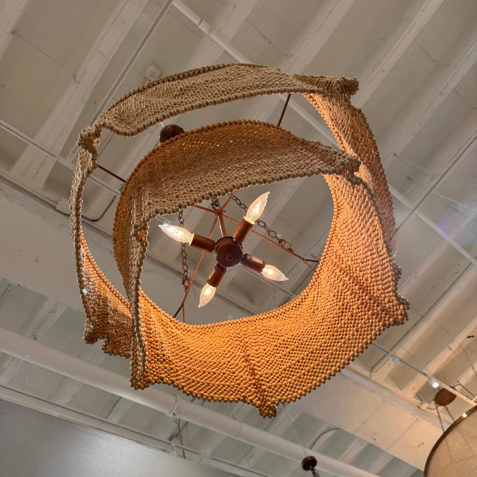 Woven basket-like chandelier hanging from a ceiling