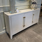 Gray kitchen island with glass countertop and metal legs on a tiled floor.