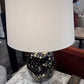 Table lamp with a black and gold speckled base on a marble surface