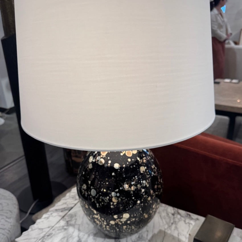 Table lamp with a black and gold speckled base on a marble surface