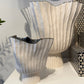 Decorative vases with ribbed design on a white surface
