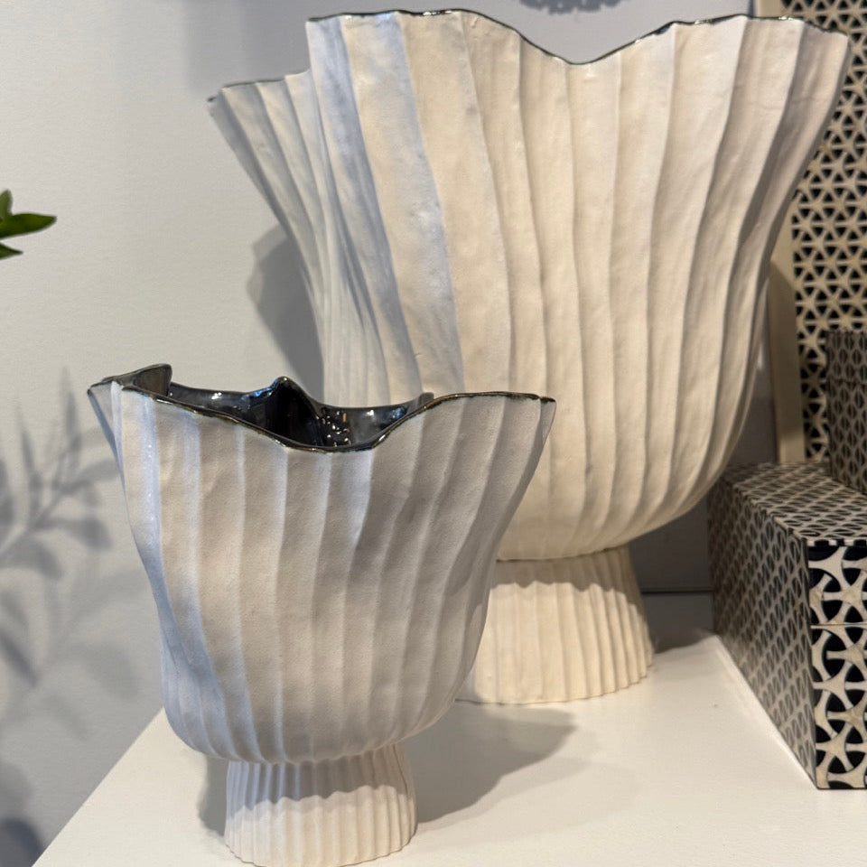 Decorative vases with ribbed design on a white surface