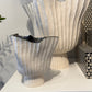 Decorative vases with ribbed design on a white surface