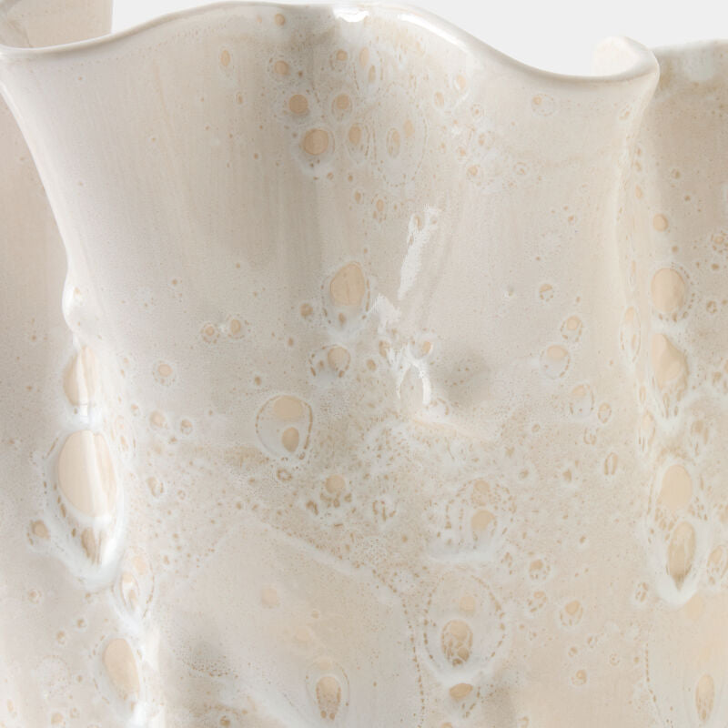 Close-up of a textured ceramic vase with a wavy design on a white background