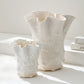 organic-shaped ceramic vases with a textured, bubbly surface and flared, wavy rim, in a warm cream or off-white glaze against a light neutral background.