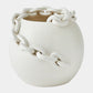White ceramic vase with chain-like design on a light gray background