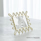 Decorative gold frame with a zebra photo on a white surface, branded 'Ashley Childers'.