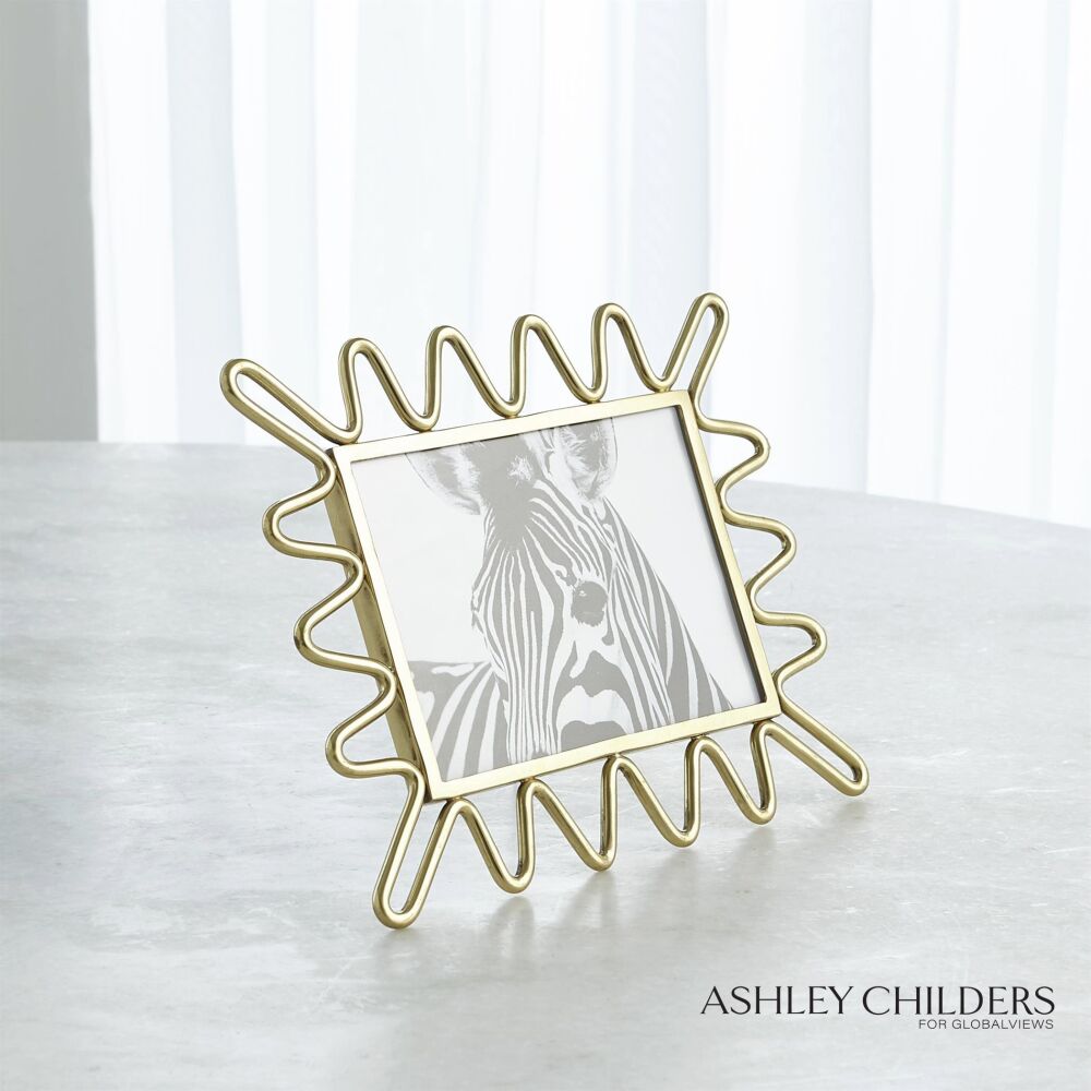 Decorative gold frame with a zebra photo on a white surface, branded 'Ashley Childers'.