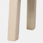 Close-up of the upholstered legs of a light beige fabric chair or stool against a plain light gray background.