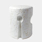 A modern cylindrical side table with a textured, speckled white finish and a central spoon-shaped cutout, shown on a light gray background.