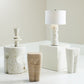 Set of ceramic vases and a lamp on a white surface with a neutral background