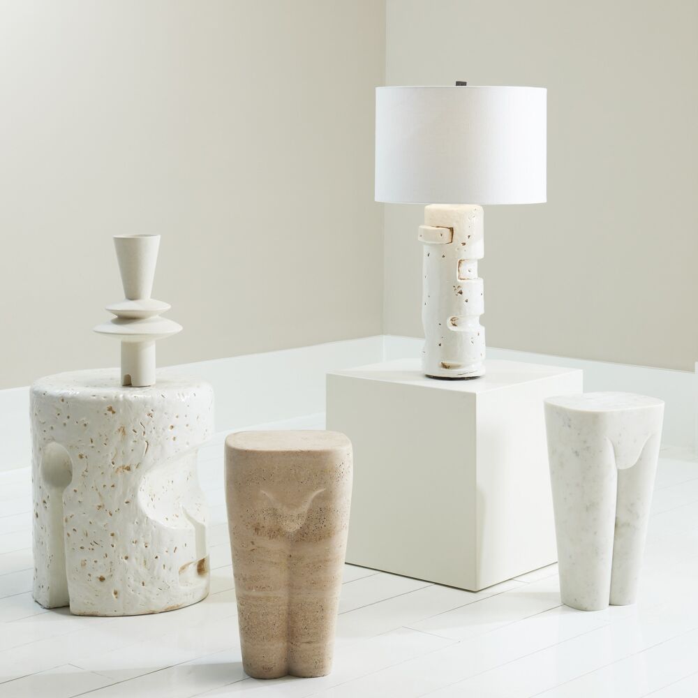 Set of ceramic vases and a lamp on a white surface with a neutral background