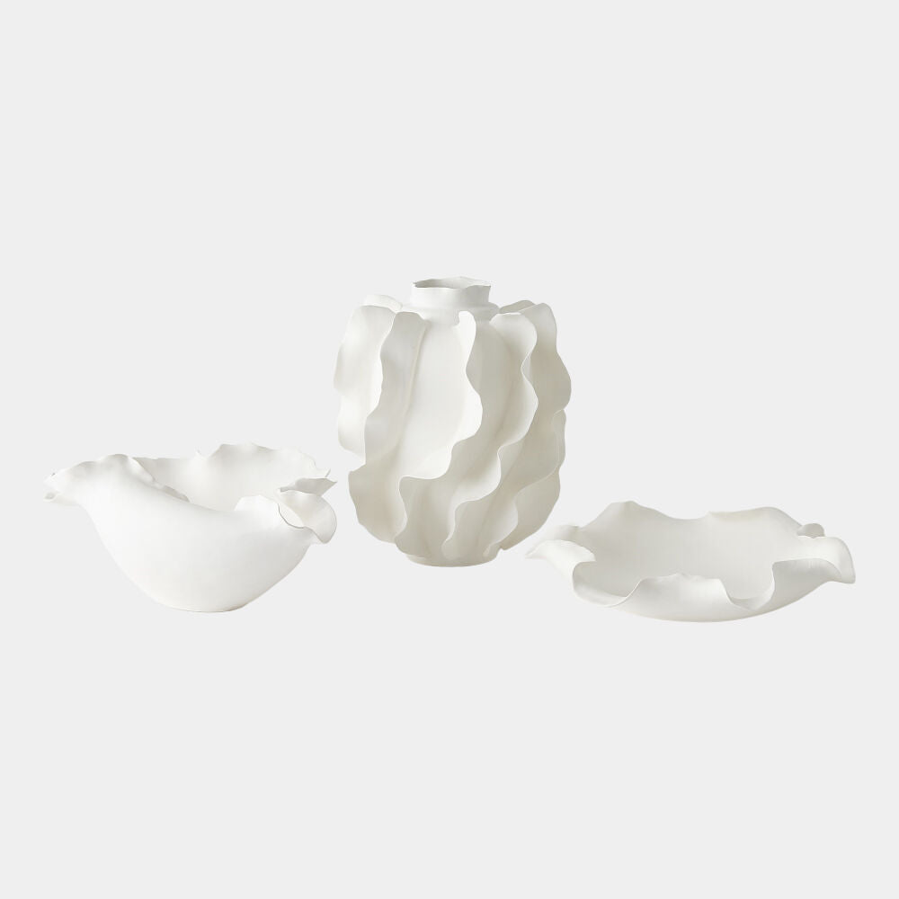Three white ceramic sculptures on a light gray background