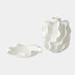 Two white ceramic vases with wavy designs on a light gray background