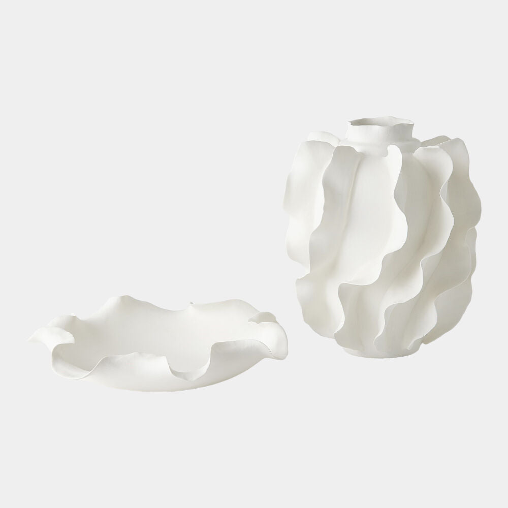 Two white ceramic vases with wavy designs on a light gray background