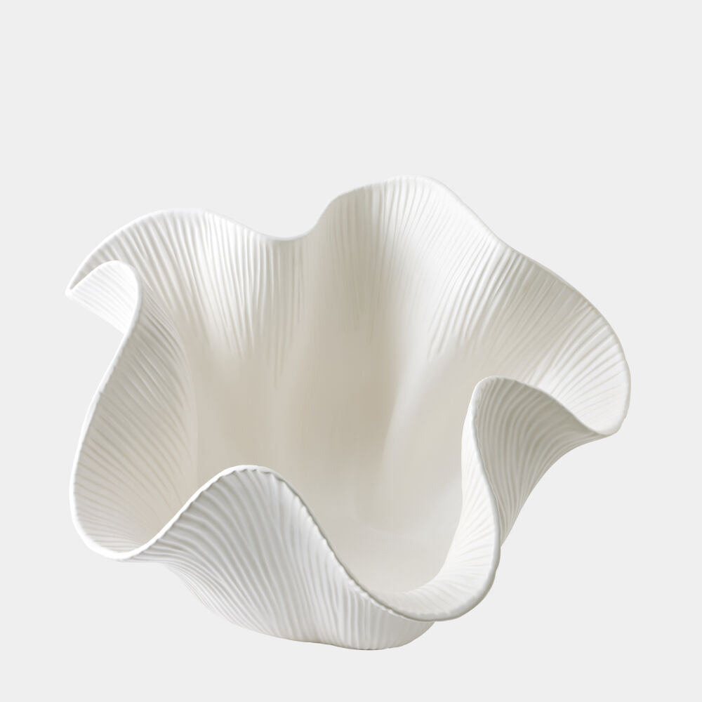White ceramic vase with wavy design on a light gray background