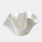 White ceramic bowl with wavy design on a light gray background