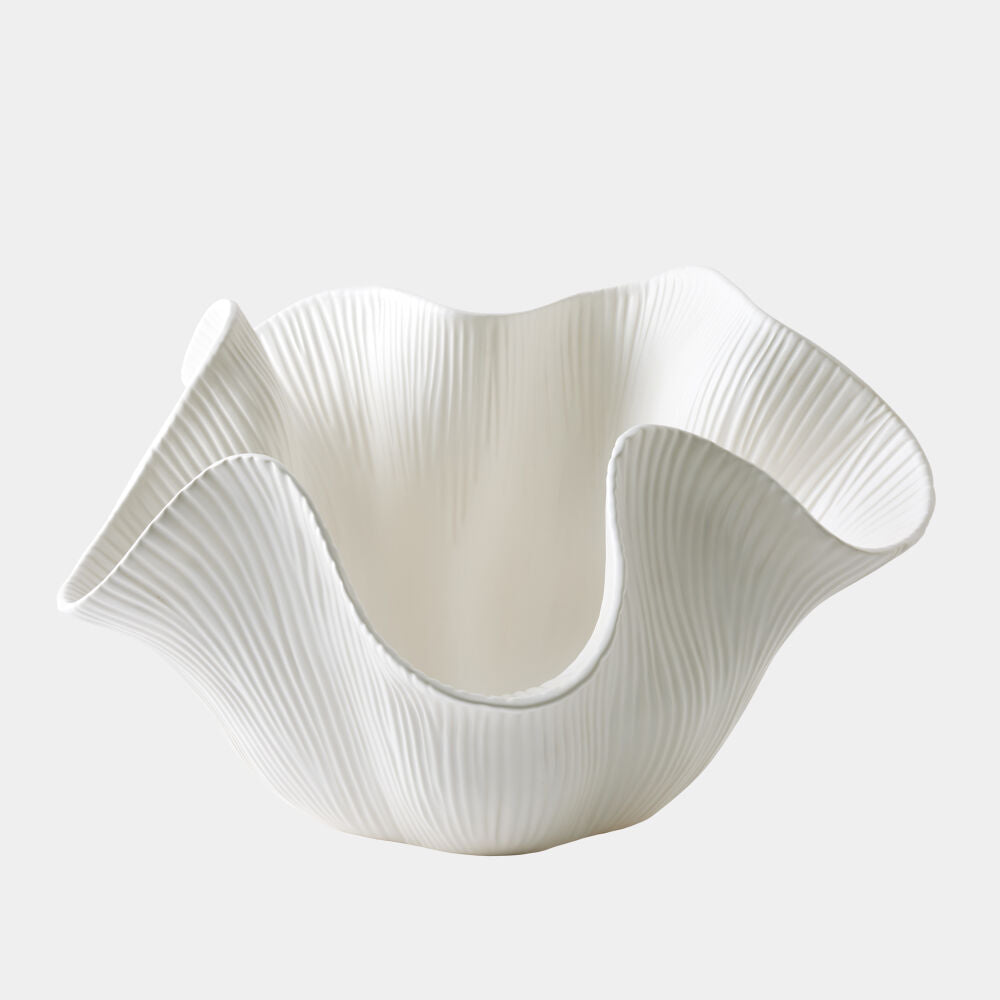 White ceramic bowl with wavy design on a light gray background